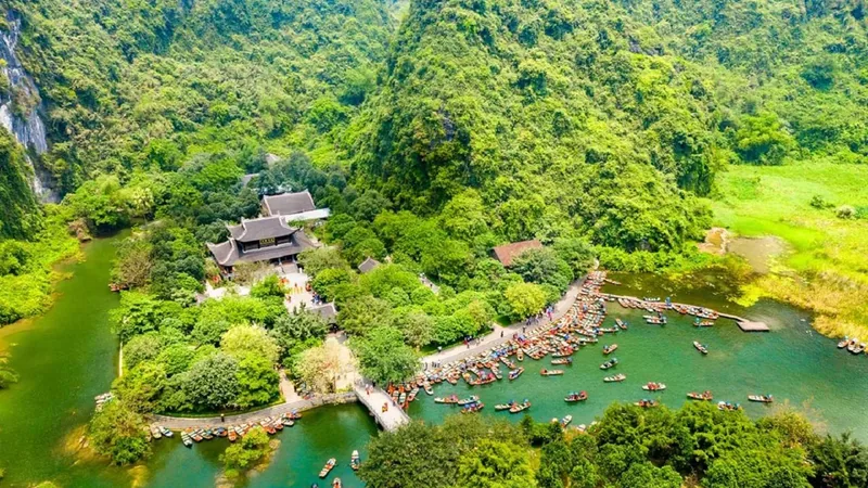 Aerial view of boats and a temple on the river at Trang An on a 2-day Vietnam tour package from Hanoi, Ninh Binh, Vietnam