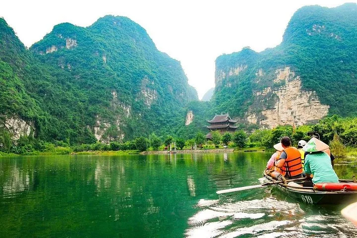 Rowing boats on the green river between limestone karsts at Trang An, Ninh Binh, on a 10-day Vietnam tour package from Hanoi to the south, Vietnam