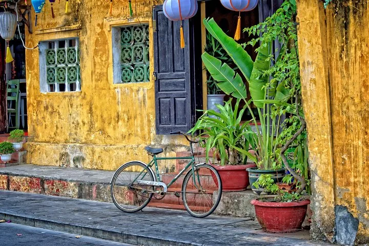 Yellow-walled Hoi An shophouse with a parked bicycle on an 8-day Vietnam tour package from Ho Chi Minh City to Ha Long Bay, Hoi An, Vietnam