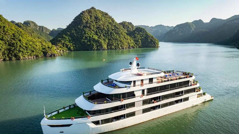 A white cruise ship among limestone islands in the bay on a 3-day Vietnam tour package with a Lan Ha Bay cruise, Ha Long Bay, Vietnam