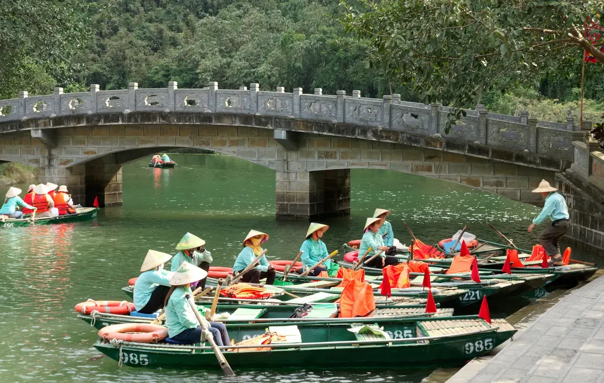 Rowing boats waiting at the Trang An wharf below the limestone hills of Ninh Binh, a stop on 2 and 3 day Vietnam tour packages from Hanoi